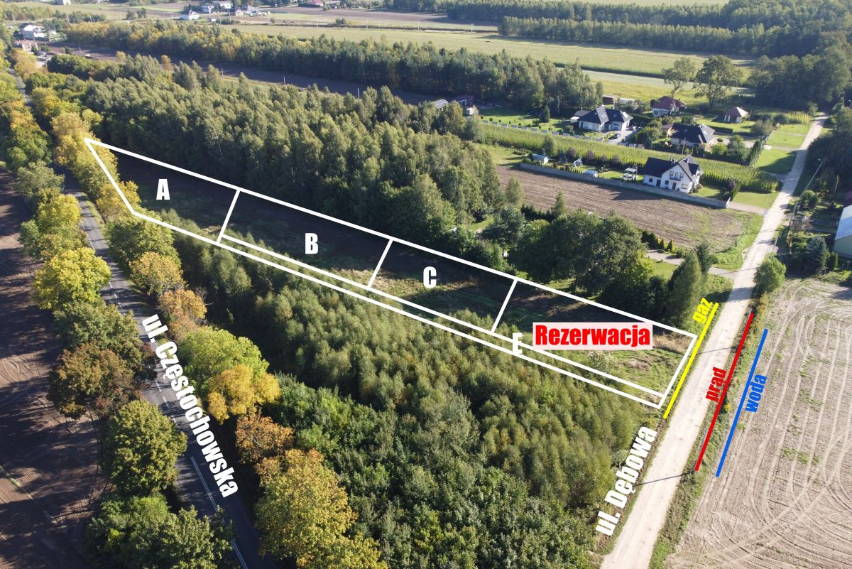 Aerial view of a wooded lot with three rectangular plots A, B, C and a reserved area labeled 'Rezerwacja' along a roadside.