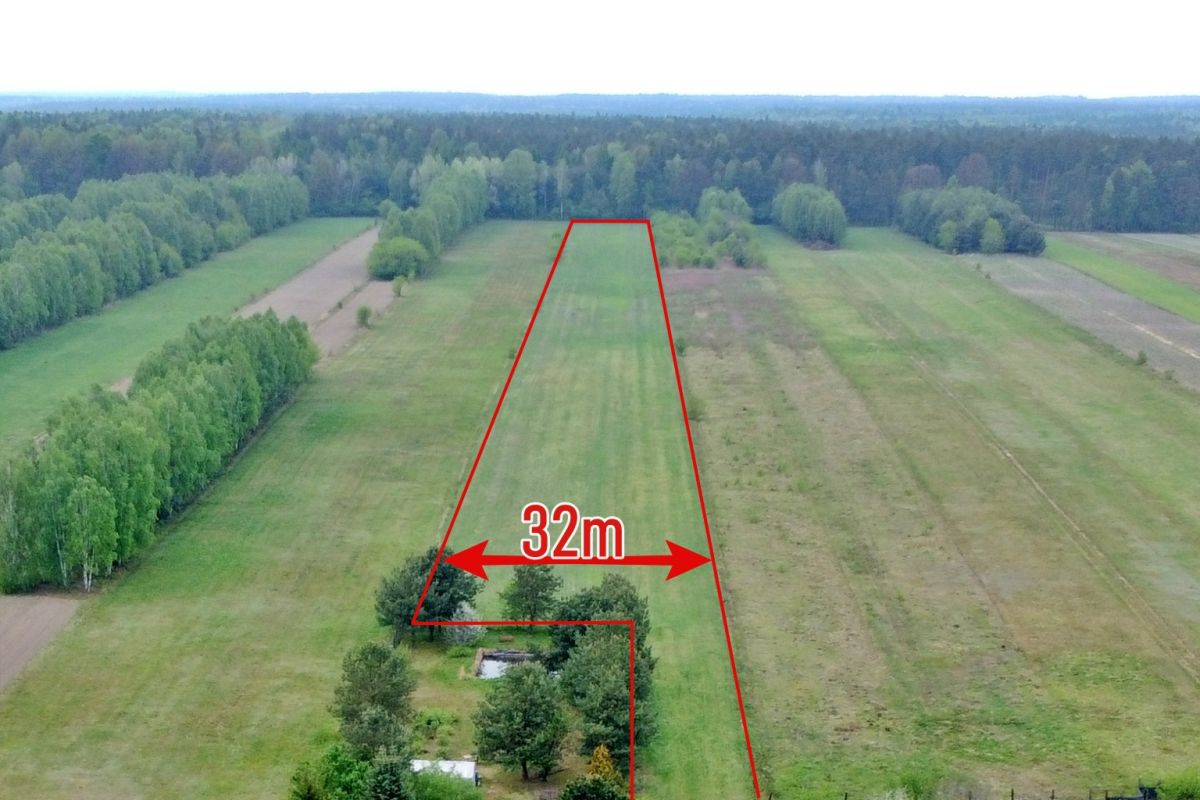 Aerial view of a long, narrow grassy plot outlined in red with a 32 m width label and surrounding trees.