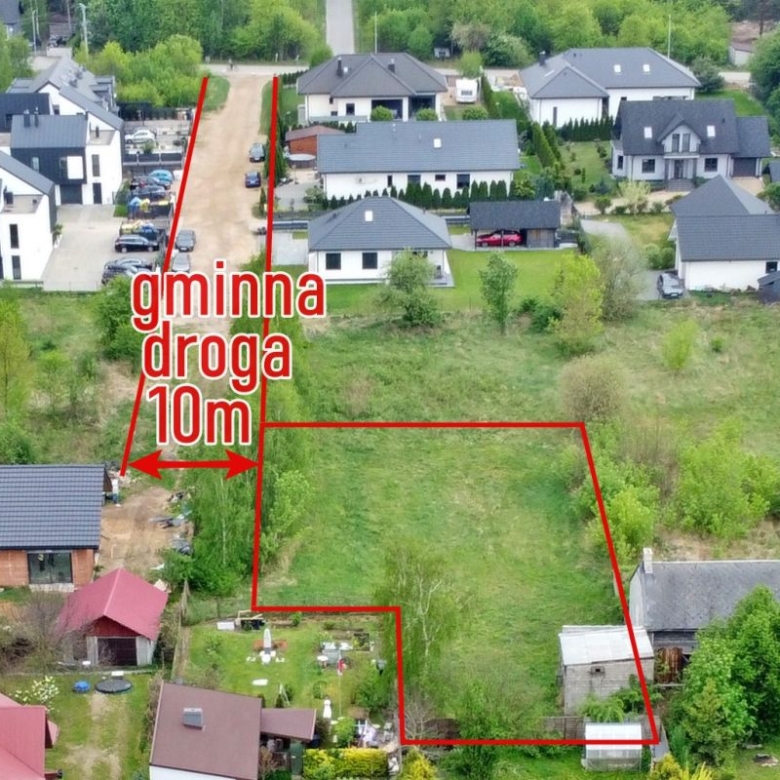 Aerial view of a residential neighborhood with a large irregular lot outlined in red, labeled '10m' along a narrow driveway, showing surrounding houses and green space.