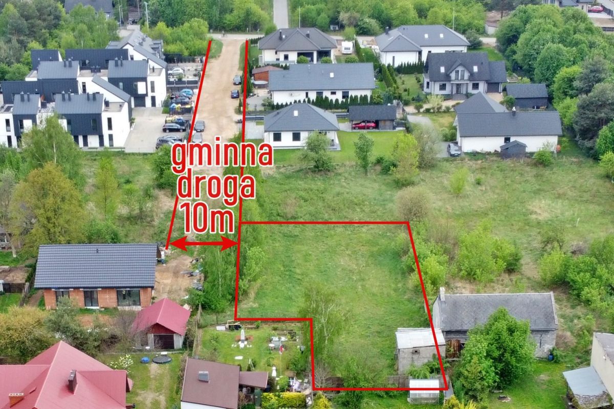 Aerial view of a residential neighborhood with a large irregular lot outlined in red, labeled '10m' along a narrow driveway, showing surrounding houses and green space.