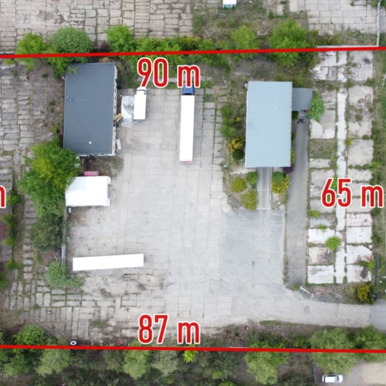 Aerial view of a rectangular lot outlined in red with labeled side lengths (top 90 m, left 60 m, right 65 m, bottom 87 m) showing several buildings and trees inside.