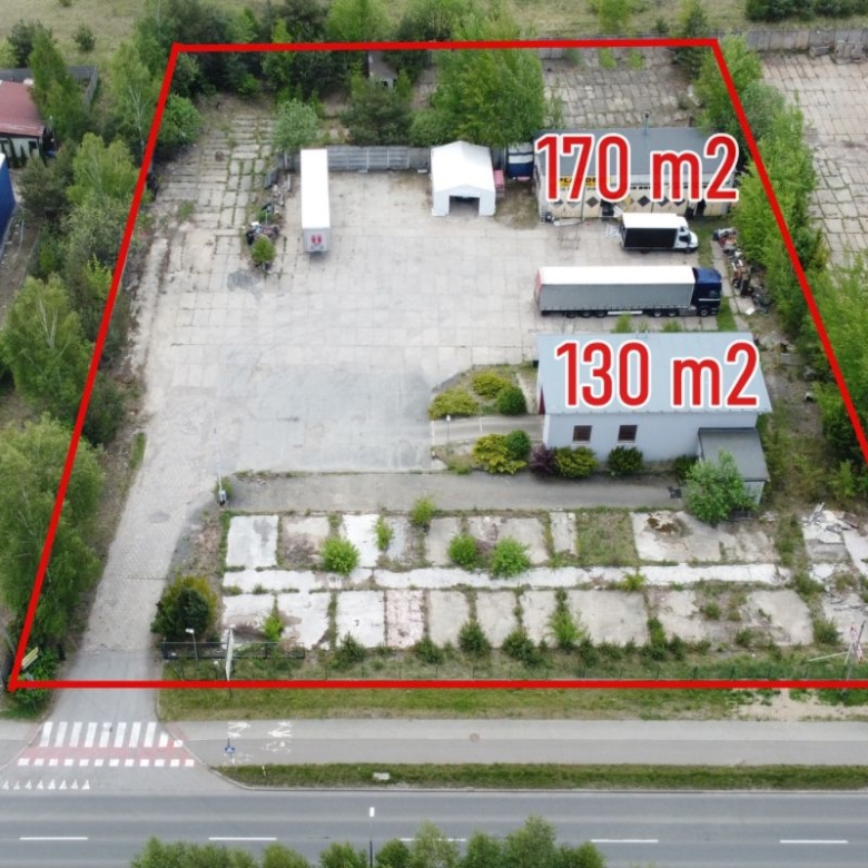 Aerial view of a fenced property subdivided into two parcels marked 170 m2 and 130 m2, with buildings and a truck nearby.