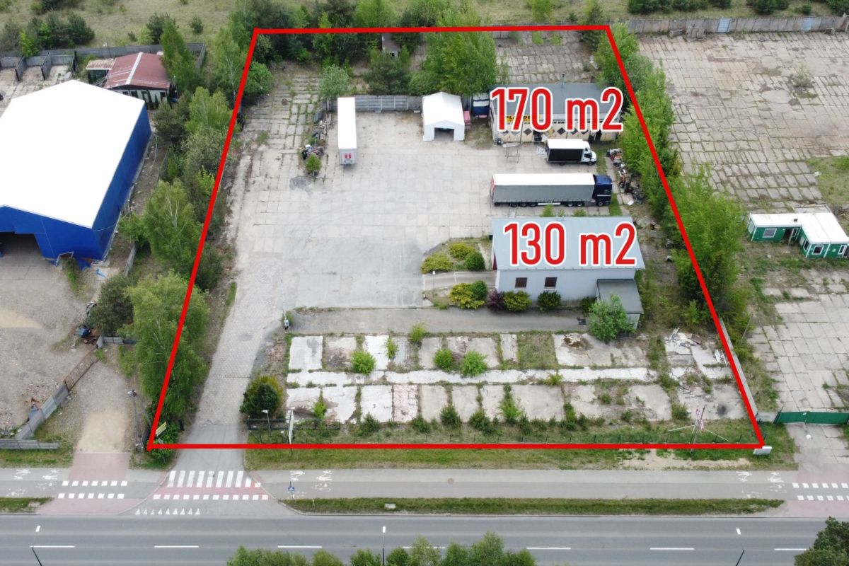 Aerial view of a fenced property subdivided into two parcels marked 170 m2 and 130 m2, with buildings and a truck nearby.