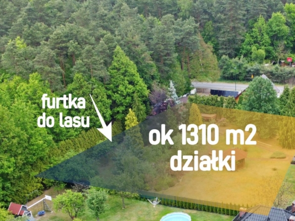 Drone view of a green, tree-filled property with a highlighted plot labeled 'ok 1310 m2 działki' and 'furtka do lasu' indicating forest access (for sale).