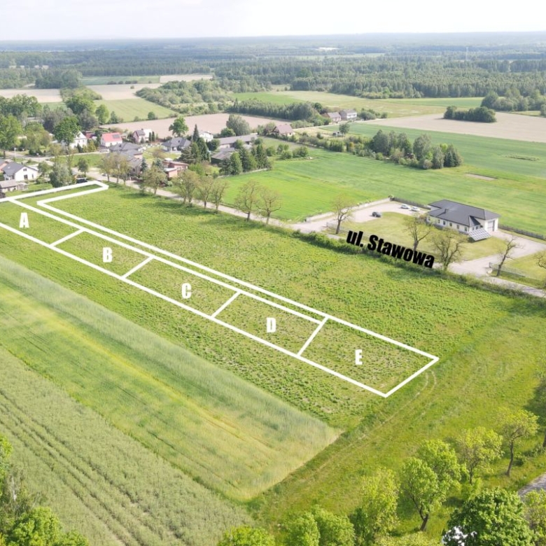 Aerial view of five rectangular plots labeled A to E outlined in white on a green field, near a street named Ul. Sławowa.