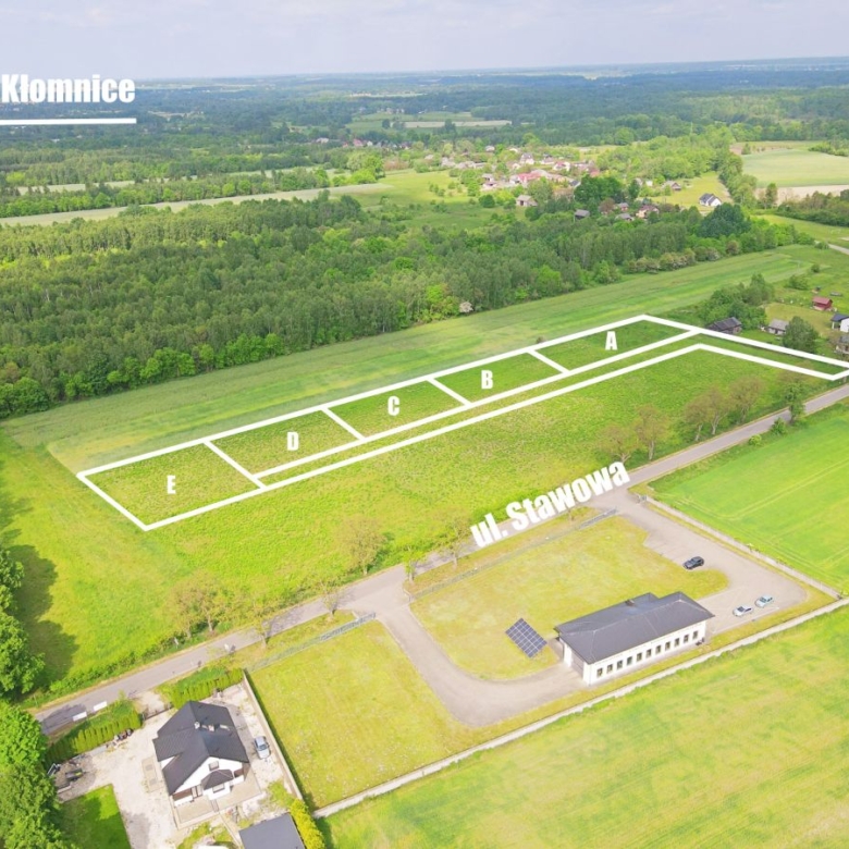 Aerial view of a subdivided plots labeled A–E along ul. Stawowa in a grassy field near a small village marked 'Kłomnice' in the distance.
