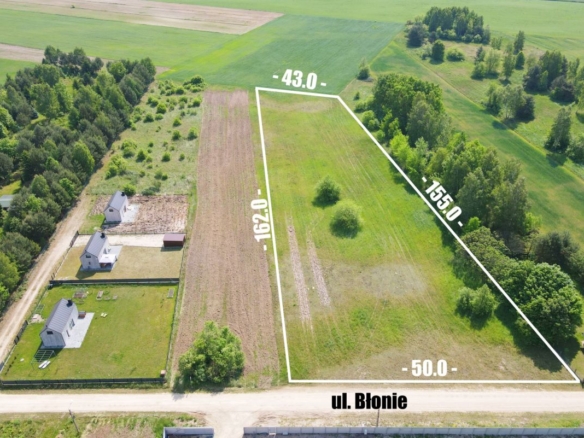 Aerial view of a rural property with a white boundary outline showing a plot along ul. Błonie; perimeter dimensions are labeled around the edge for context.