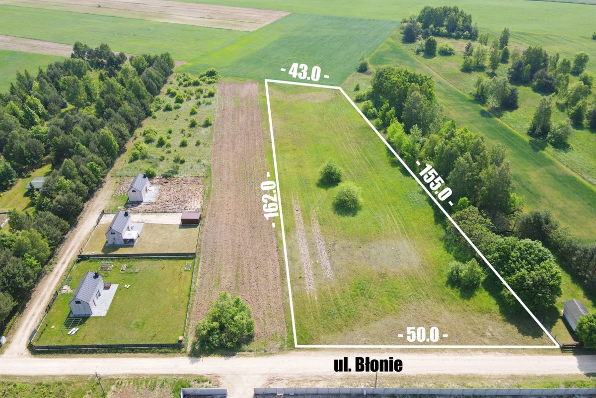 Aerial view of a rural property with a white boundary outline showing a plot along ul. Błonie; perimeter dimensions are labeled around the edge for context.