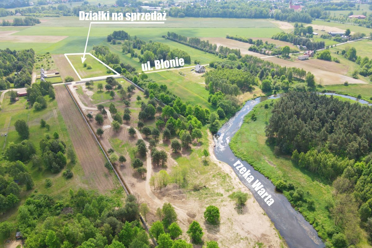 Aerial view of countryside with marked plots for sale labeled 'Działki na sprzedaż', nearby street Ul. Blonie, and the Warta River nearby.