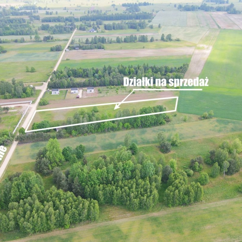 Aerial view of farmland with a white outline marking sale plots along a road, labeled Działki na sprzedaż near Ul. Błonie.