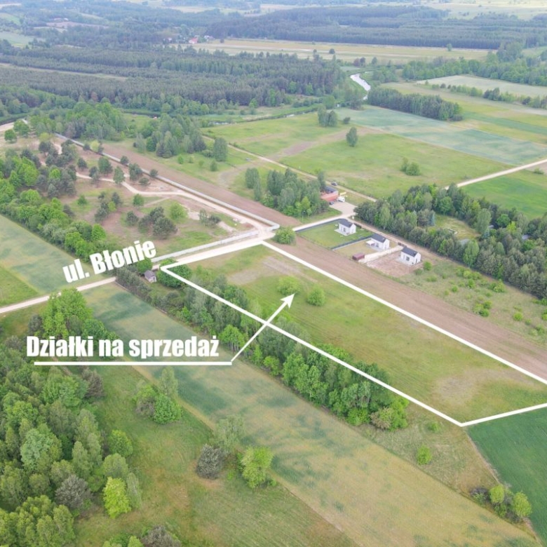 Aerial view of farmland with white boundary lines marking plots for sale and a street labeled ul. Błonie