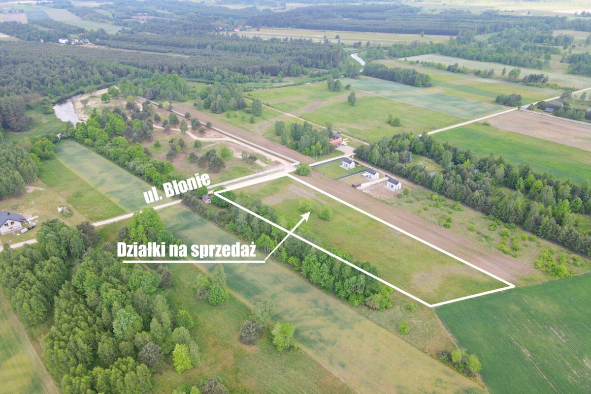 Aerial view of farmland with white boundary lines marking plots for sale and a street labeled ul. Błonie