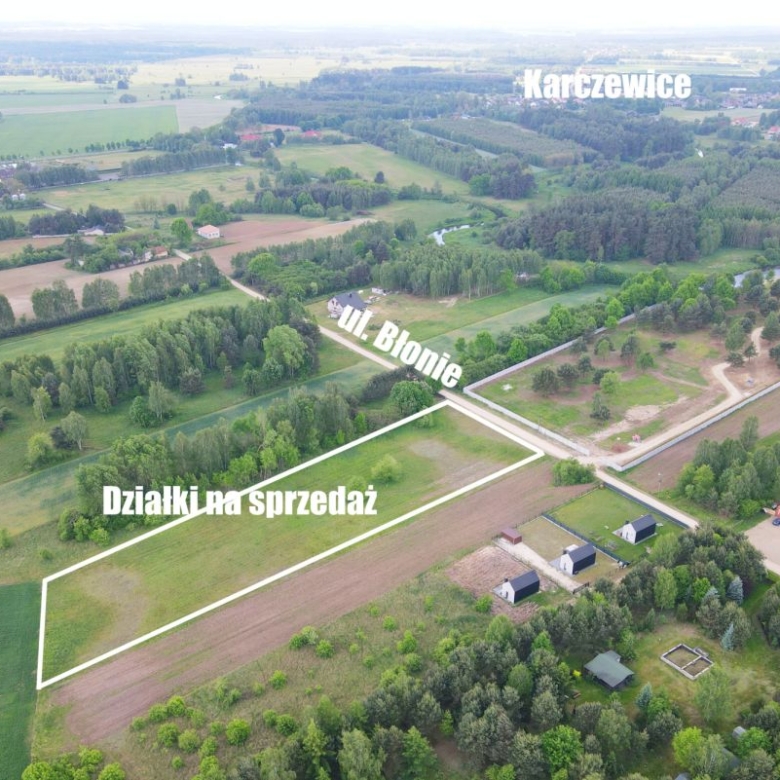 Aerial view of rural plots outlined in white for sale, labeled 'Działki na sprzedaż' near Ul. Błonie, Kartzewice