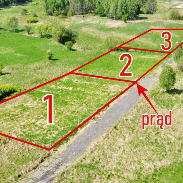 Aerial view of three red-outlined land plots labeled 1, 2, and 3 along a road, with a blue boundary and an arrow pointing to a utility line labeled 'prąd' (power).
