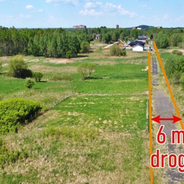 Rural road through fields with orange lines marking a 6 m road width and red text reading '6 m drogi'