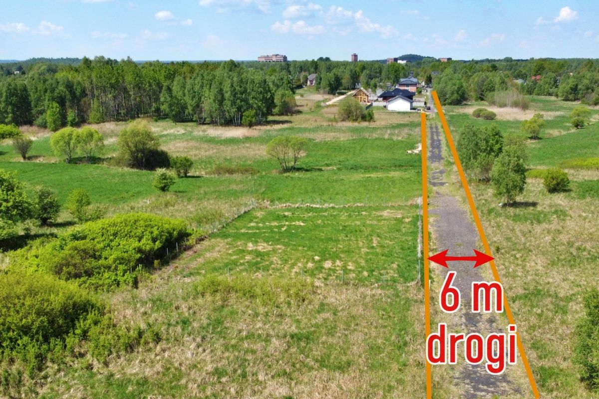 Rural road through fields with orange lines marking a 6 m road width and red text reading '6 m drogi'