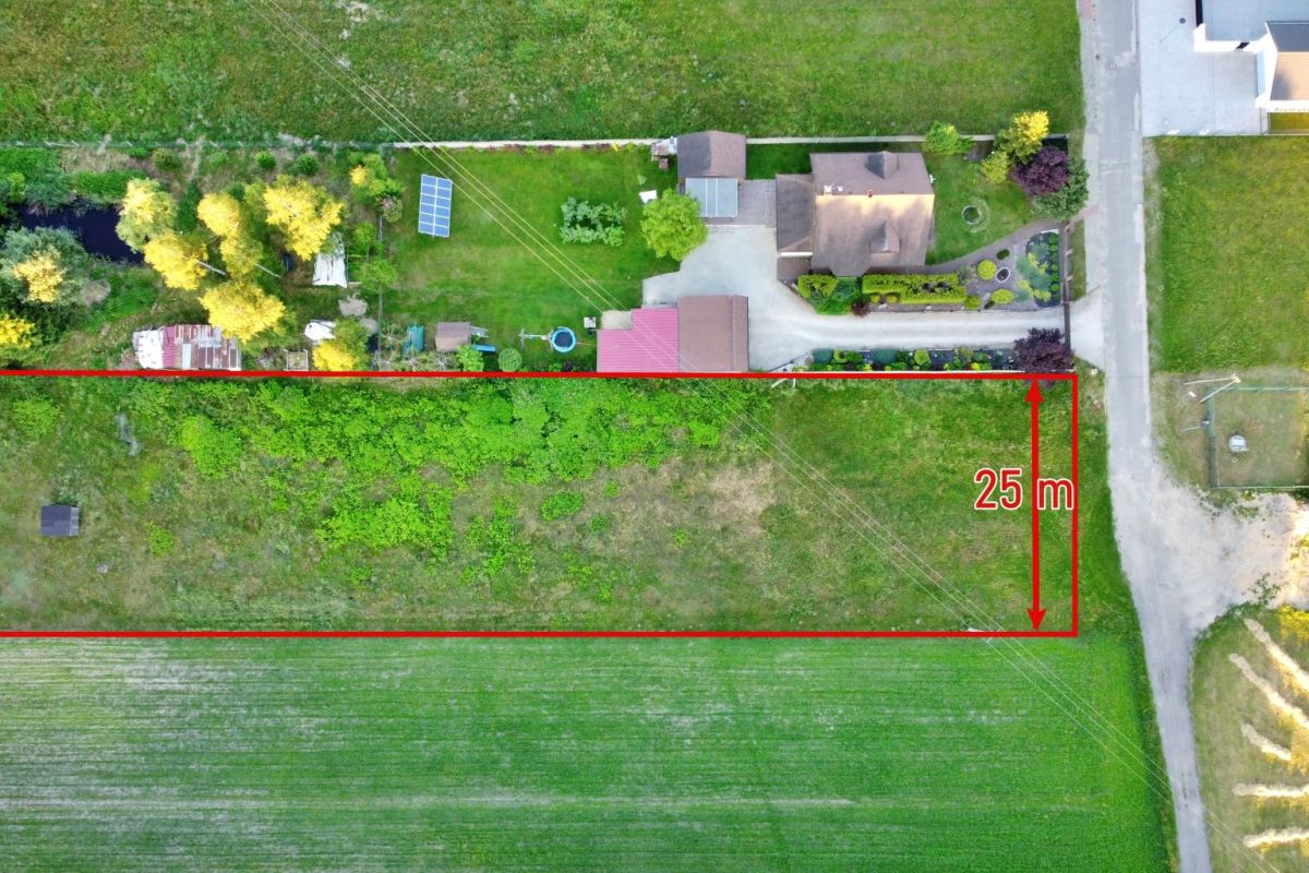 Aerial view of a rectangular plot outlined in red with a 25 m right-side dimension beside a road.