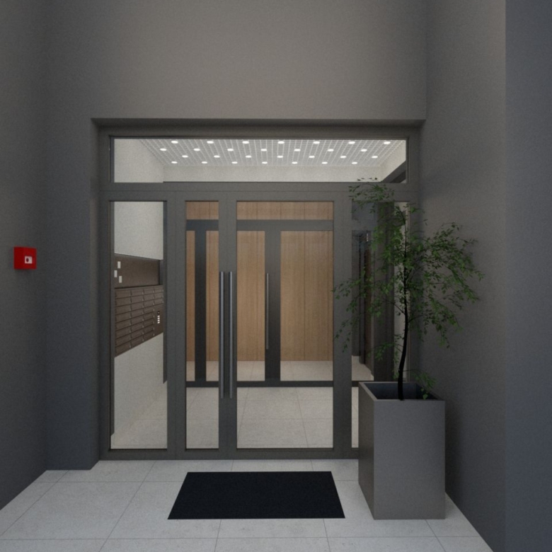 Lobby entrance with glass double doors and long metal handles, gray walls, a black entry mat, and a tall plant in a gray planter to the right.
