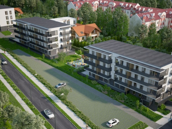 view of modern multi-story apartment buildings set in a green residential area with a road, cars, and a playground nearby