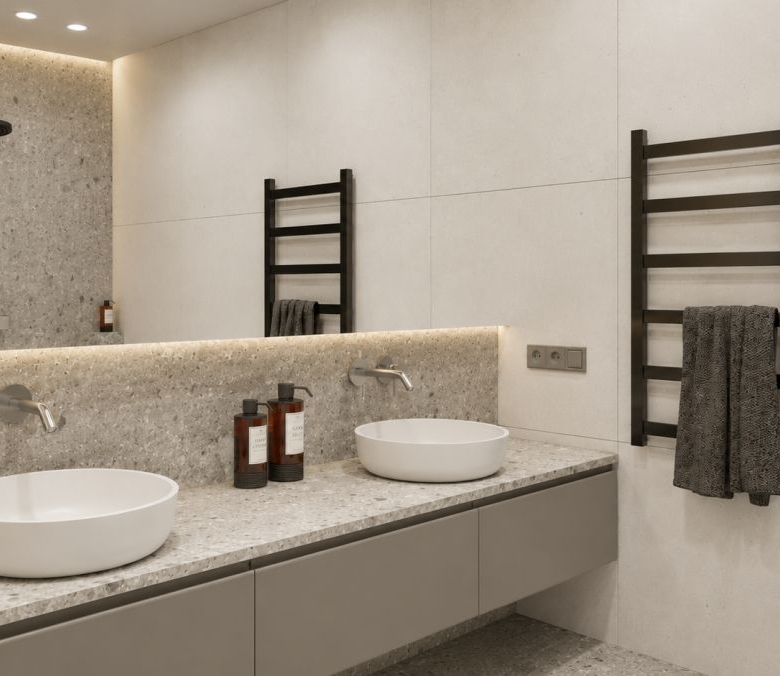 Modern bathroom vanity with two white round vessel sinks on a speckled gray countertop, wall-mounted faucets, and a dark ladder-style towel rack on the right.