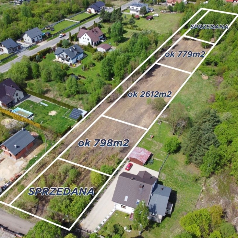 Aerial view of a housing subdivision with outlined plots and labels showing sold and sizes (e.g., ~779m2, ~2612m2, ~798m2) in Polish area names.