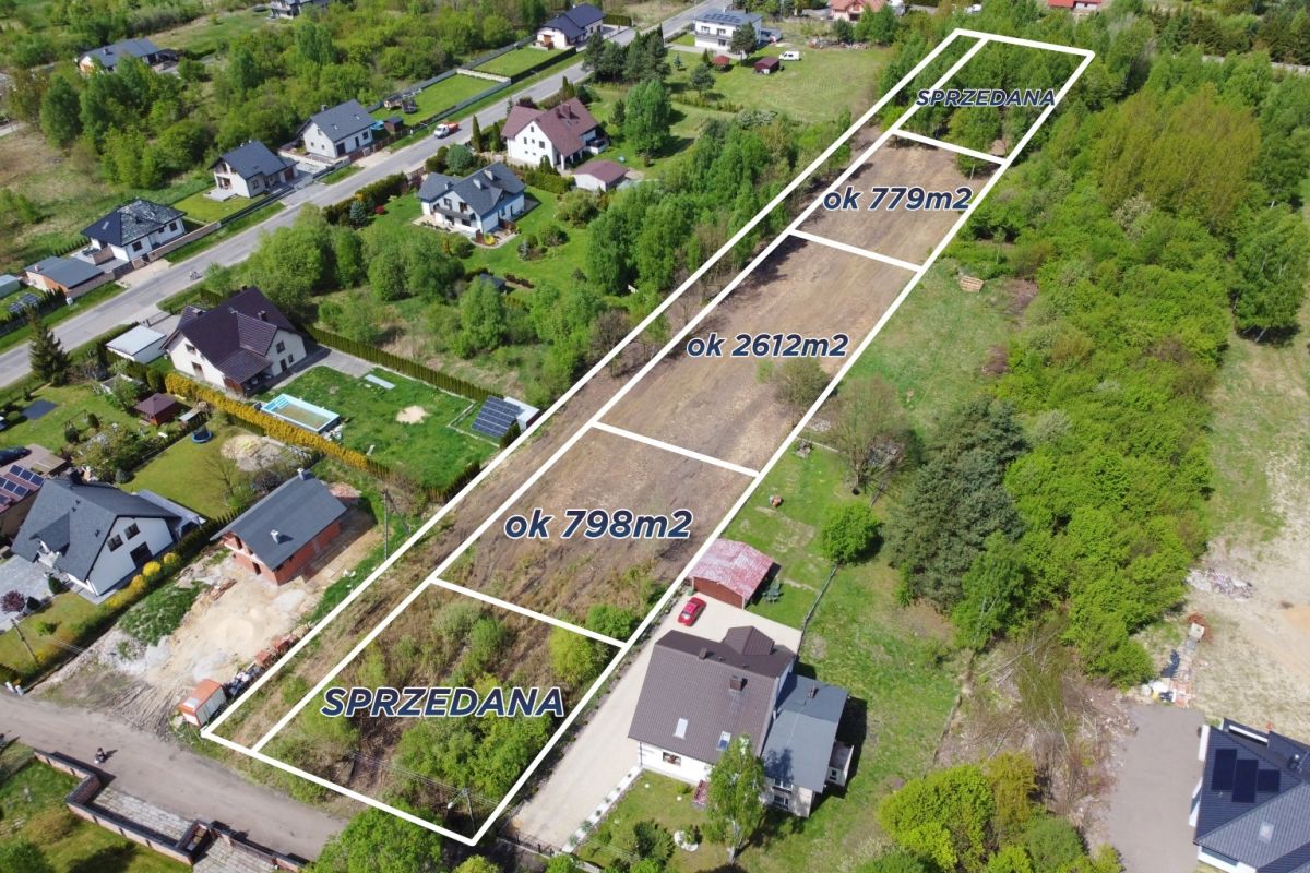 Aerial view of a housing subdivision with outlined plots and labels showing sold and sizes (e.g., ~779m2, ~2612m2, ~798m2) in Polish area names.