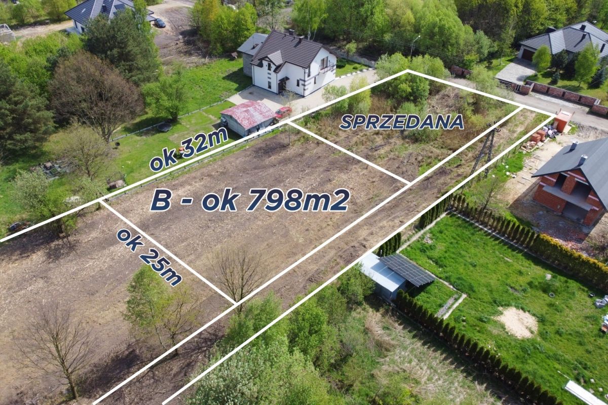 110959778.jpg Aerial view of a land plot with white boundary lines showing a large B plot (~798 m2) and two smaller sections labeled 32 m and 25 m, one area marked SPRZEDANA (sold).