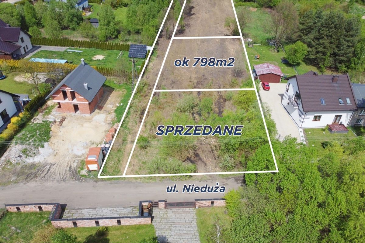Aerial view of a vacant plot outlined in white, labeled ok 798m2 and SPRZEDANE, on ul. Nieduża between houses.