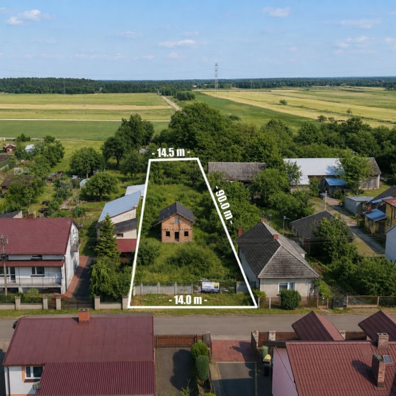 Aerial view of a triangular vacant lot outlined in white between houses, with dimensions 14.0 m base, 14.5 m top, and 29.0 m side, in a village setting.